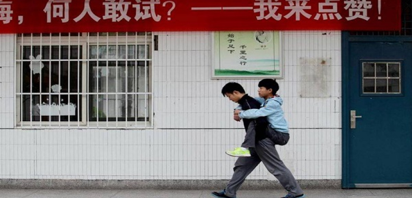 على الطريقة الصينية.. طالب يحمل صديقه على ظهره لمدة 3 سنوات يوميًا