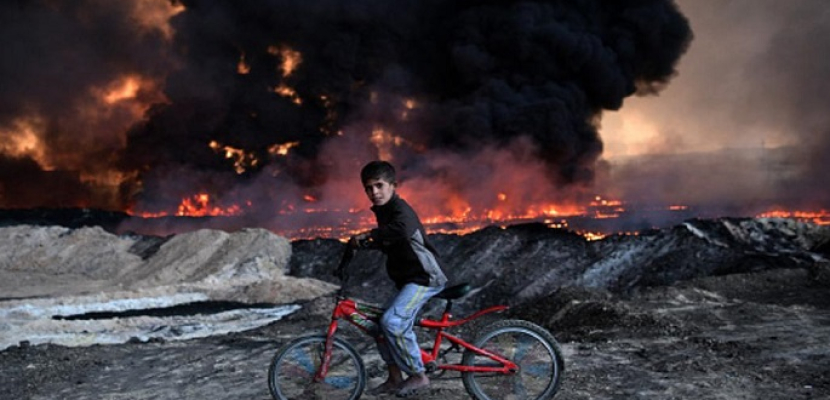 بالصور ..  أطفال الموصل وسط دخان النفط المحترق